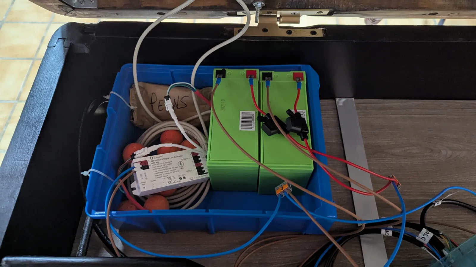 Las dos baterías de plomo y el controlador Gledopto dentro de una caja azul