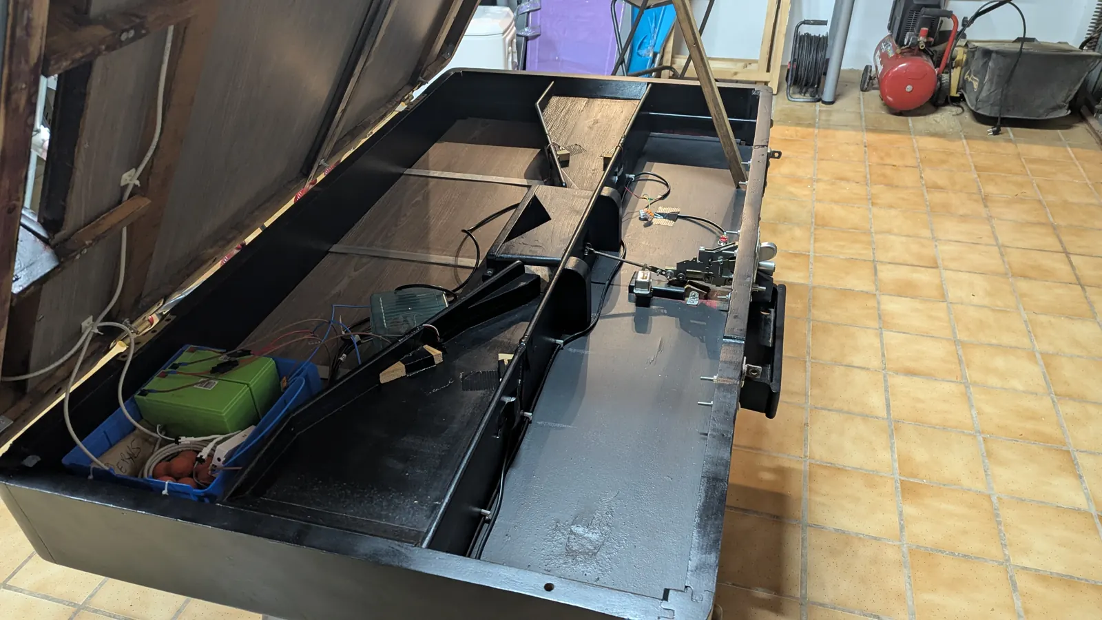 El futbolín con el tablero de juego abatido y la electrónica dentro del mueble